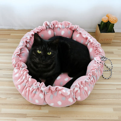 félin installé confortablement sur son coussin à chat rose à coeurs
