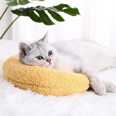félin confortablement installé sur son coussin banane pour chat jaune