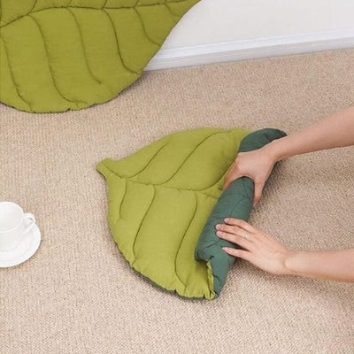 une femme roulant le coussin chat sur lui-même pour le ranger
