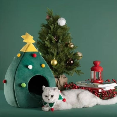 félin allongé sereinement devant le lit chat en forme de sapin de noël