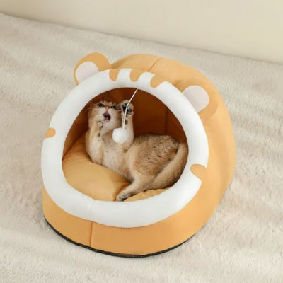 félin jouant dans son lit pour chat orange